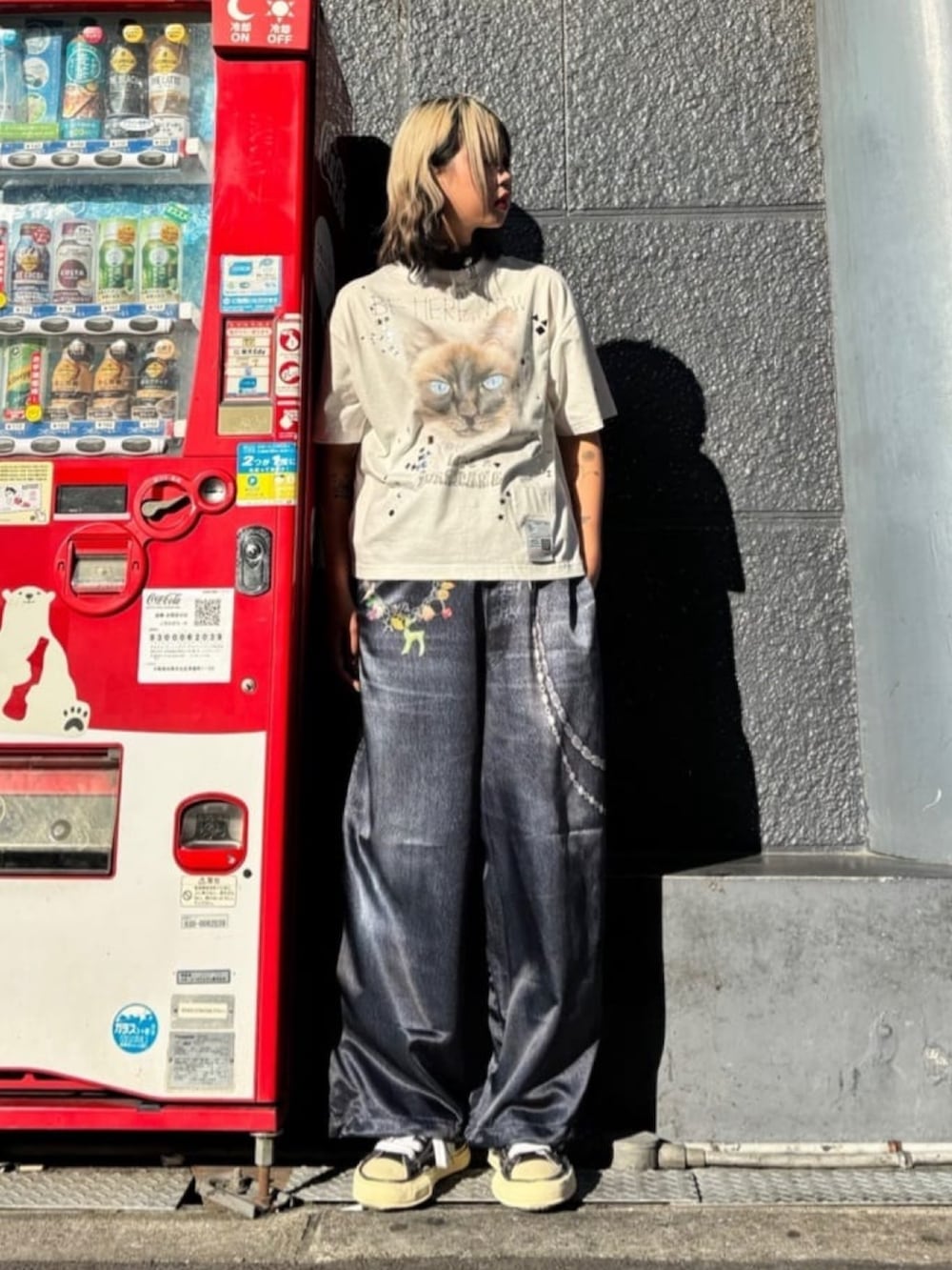 ブラック系のスニーカー、ブルー系のパンツ、ホワイト系のTシャツ/カットソーを着用したレディースの秋コーディネートの2枚目の写真