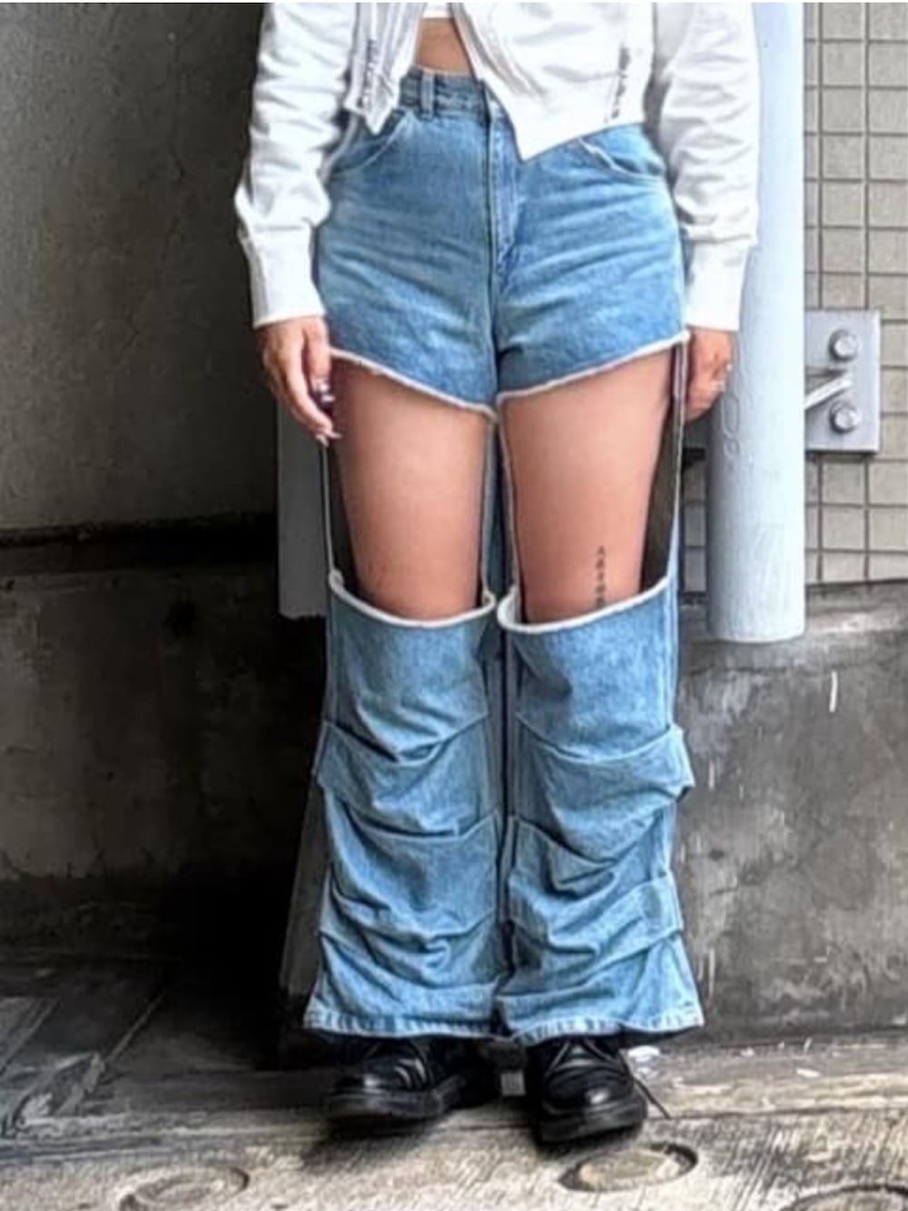 ブルー系のデニムパンツ、ホワイト系のパーカー、ブラック系のキャップを着用したレディースの秋コーディネートの5枚目の写真