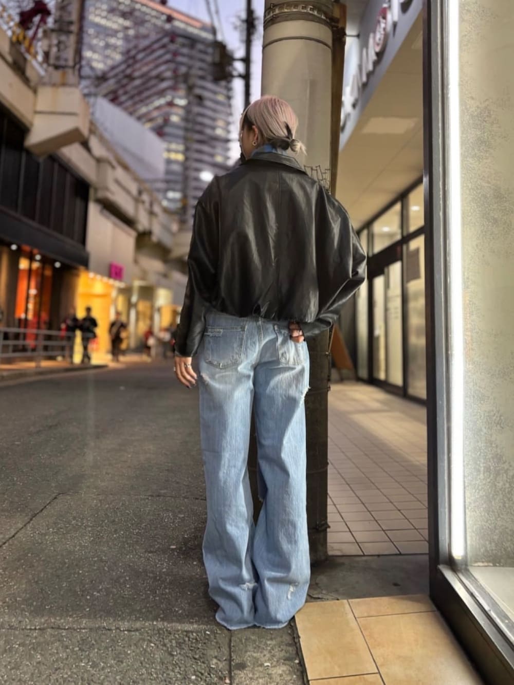 ブルー系のデニムパンツ、グレー系のニット/セーター、ブラック系のその他アウターを着用したレディースの冬コーディネートの2枚目の写真