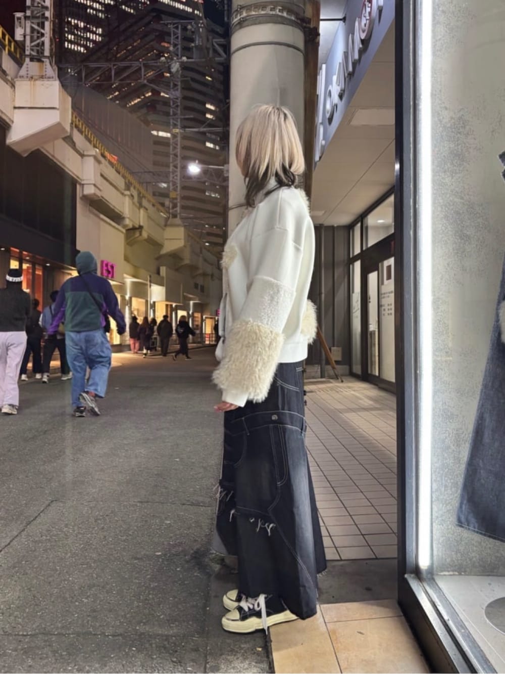 ブラック系のスカート、ホワイト系のブルゾン、ブラック系のスニーカーを着用したレディースの冬コーディネートの2枚目の写真