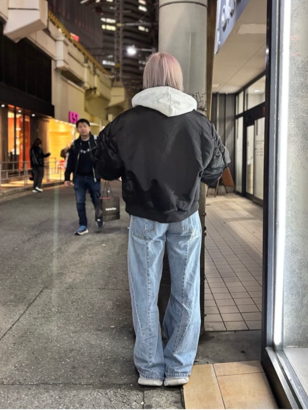 ホワイト系のパーカー、ブラック系のMA-1を着用したレディースの冬コーディネートの3枚目の写真