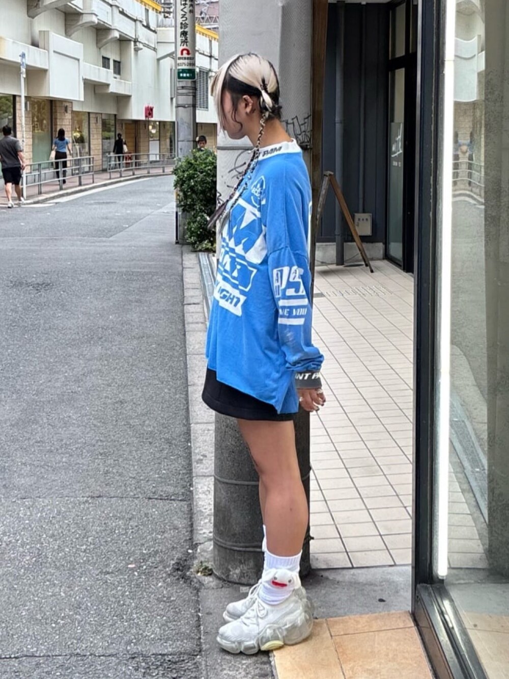 ブルー系のトップス、ホワイト系のスニーカーを着用したレディースの秋コーディネートの2枚目の写真