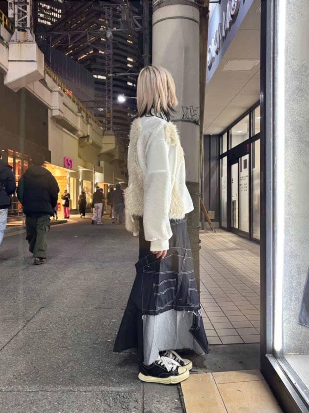 ブラック系のスカート、ホワイト系のブルゾン、ブラック系のスニーカーを着用したレディースの冬コーディネートの4枚目の写真