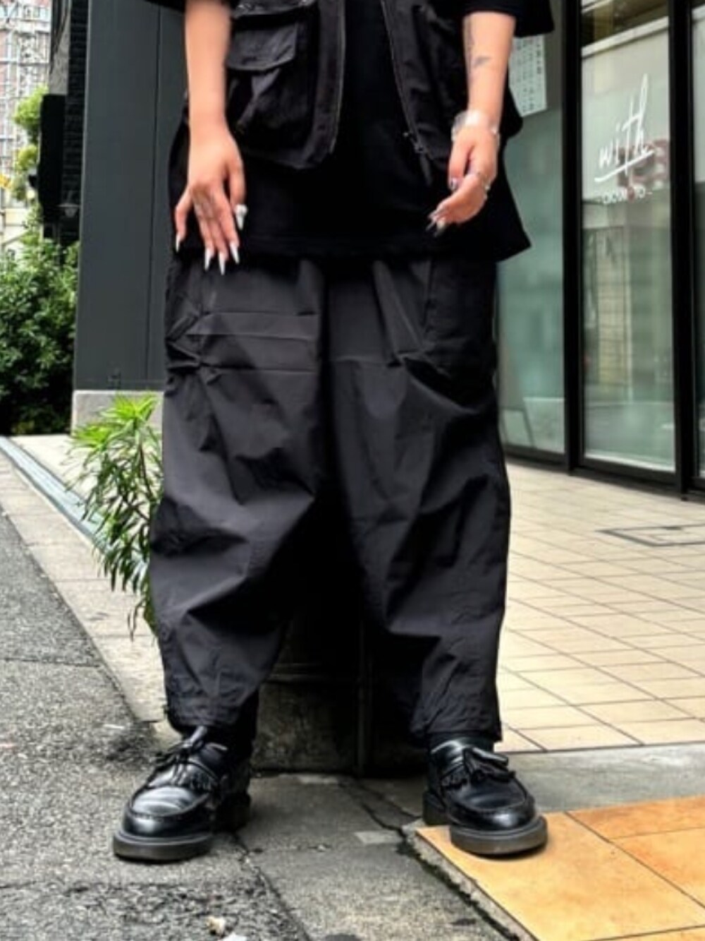 ブラック系のカーゴパンツ、ブラック系のベストを着用したレディースの春コーディネートの2枚目の写真