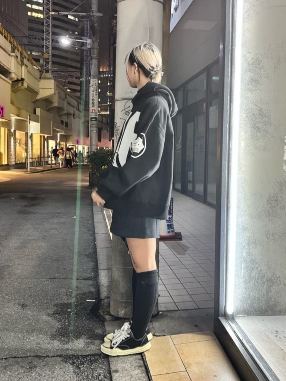 ブラック系のトップスを着用したレディースの秋コーディネートの2枚目の写真