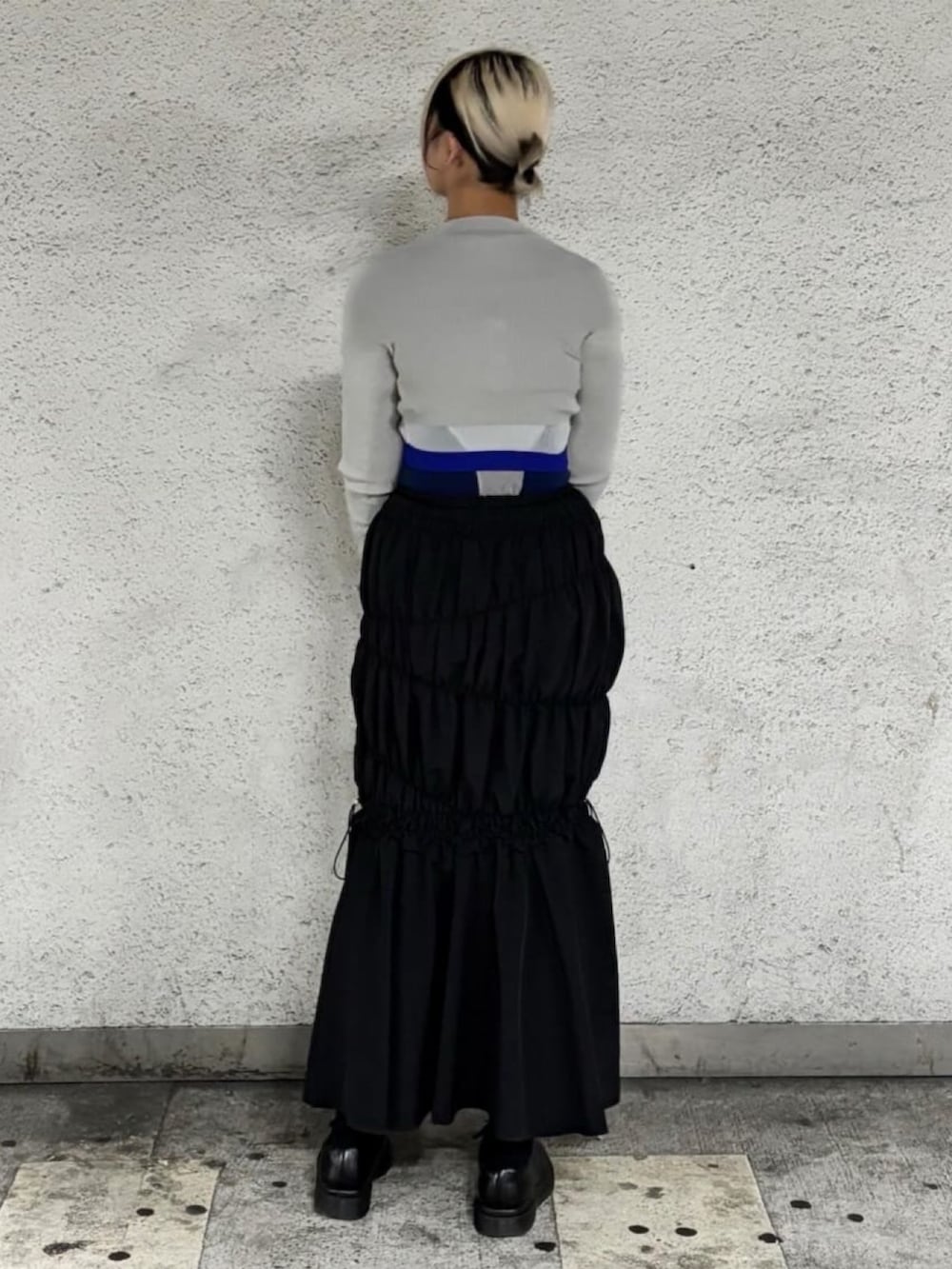 ブラック系のスカート、ブルー系のTシャツ/カットソー、グレー系のトップスを着用したレディースの夏コーディネートの3枚目の写真