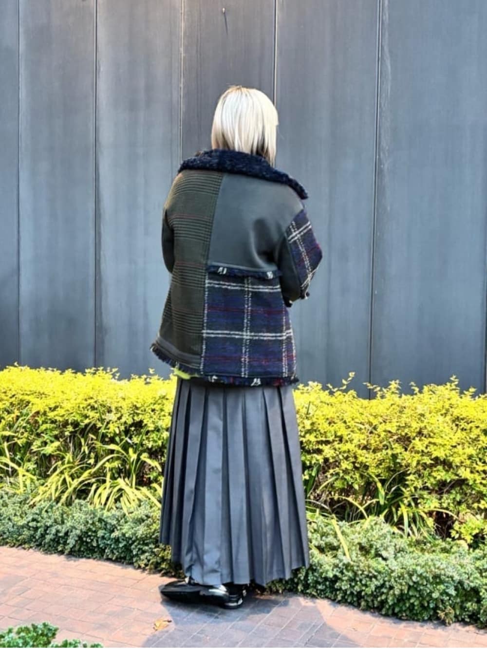 イエロー系のニット/セーター、グリーン系のブルゾン、グレー系のスカートを着用したレディースの冬コーディネートの5枚目の写真