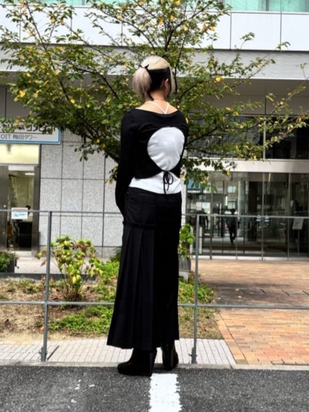 ブラック系のスカート、ホワイト系のTシャツ/カットソーを着用したレディースの秋コーディネートの3枚目の写真