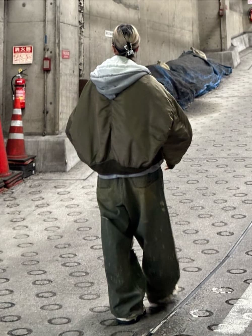 グリーン系のジャケット/アウター、レッド系のTシャツ/カットソー、ブルー系のデニムパンツを着用したレディースの秋コーディネートの3枚目の写真