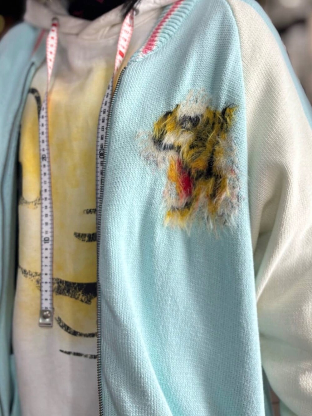 ホワイト系のパーカー、ブルー系のジャケット/アウター、ブラック系のスニーカーを着用したレディースの冬コーディネートの5枚目の写真