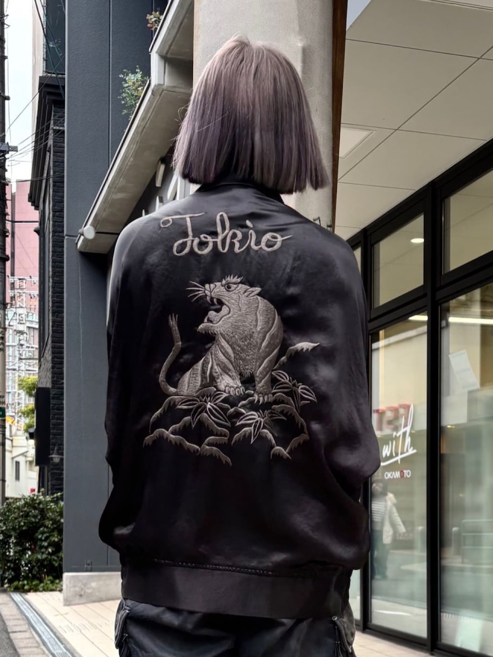 ブラック系のパンツ、ブラック系のスニーカー、ブラック系のブルゾンを着用したレディースの春コーディネートの2枚目の写真