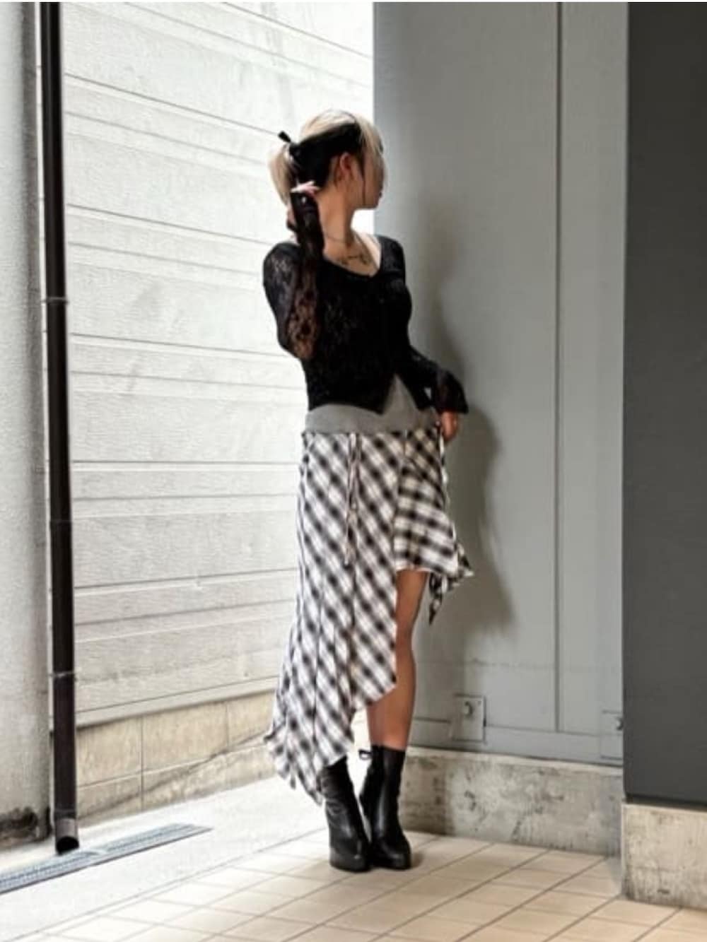 ブラック系のスカート、ホワイト系のTシャツ/カットソー、ブラック系のTシャツ/カットソーを着用したレディースの秋コーディネートの2枚目の写真