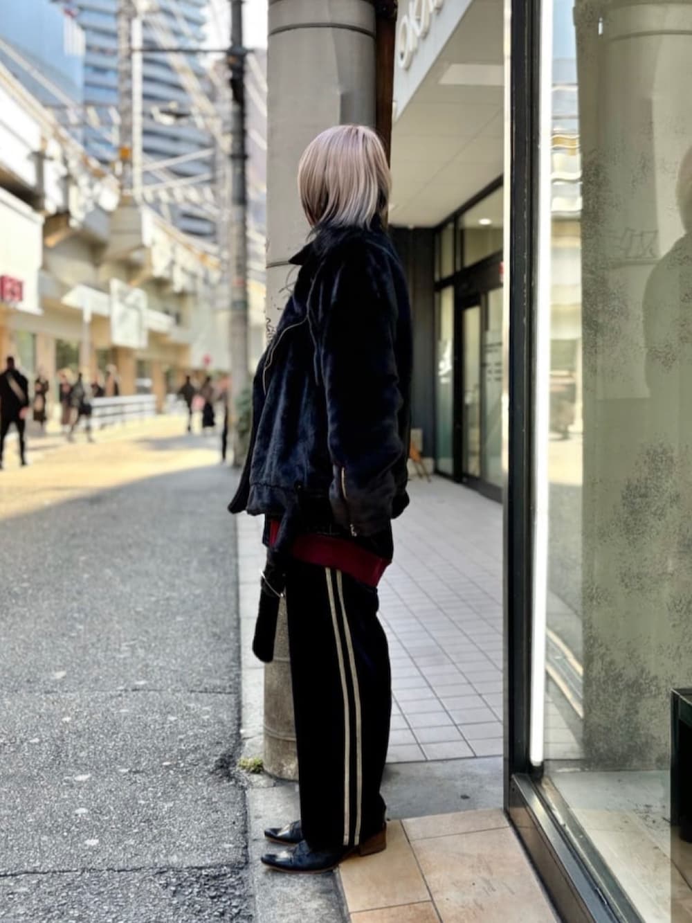 ブラック系のジャケット/アウター、ブルー系のパンツを着用したレディースの冬コーディネートの2枚目の写真