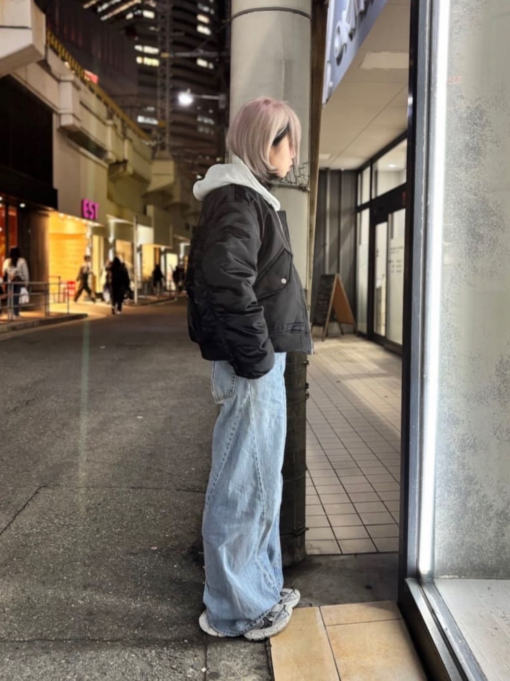 ホワイト系のパーカー、ブラック系のMA-1を着用したレディースの冬コーディネートの2枚目の写真