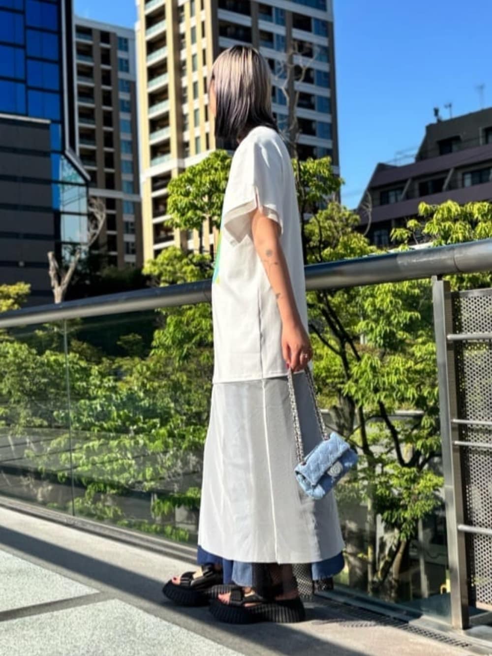 ホワイト系のチュニック、ブルー系のワンピース、ブルー系のバッグを着用したレディースの秋コーディネートの3枚目の写真