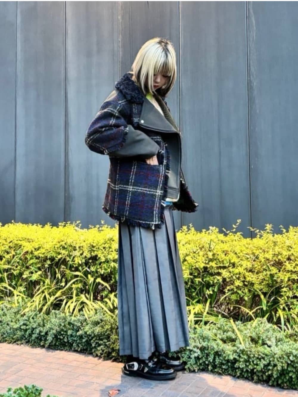 イエロー系のニット/セーター、グリーン系のブルゾン、グレー系のスカートを着用したレディースの冬コーディネートの3枚目の写真