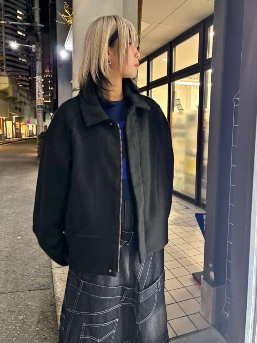 ブラック系のその他アウター、ブラック系のスカート、ブルー系のニット/セーターを着用したレディースの冬コーディネートの4枚目の写真