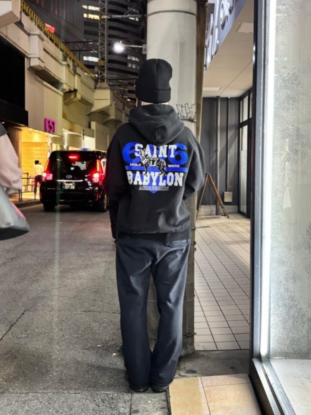 ブラック系のトップス、ブルー系のパンツ、ブラック系の帽子を着用したレディースの冬コーディネートの4枚目の写真