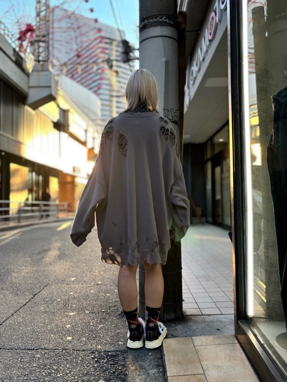 ブラック系のスニーカー、グレー系のニット/セーター、ブラック系のシャツ/ブラウスを着用したレディースの冬コーディネートの3枚目の写真