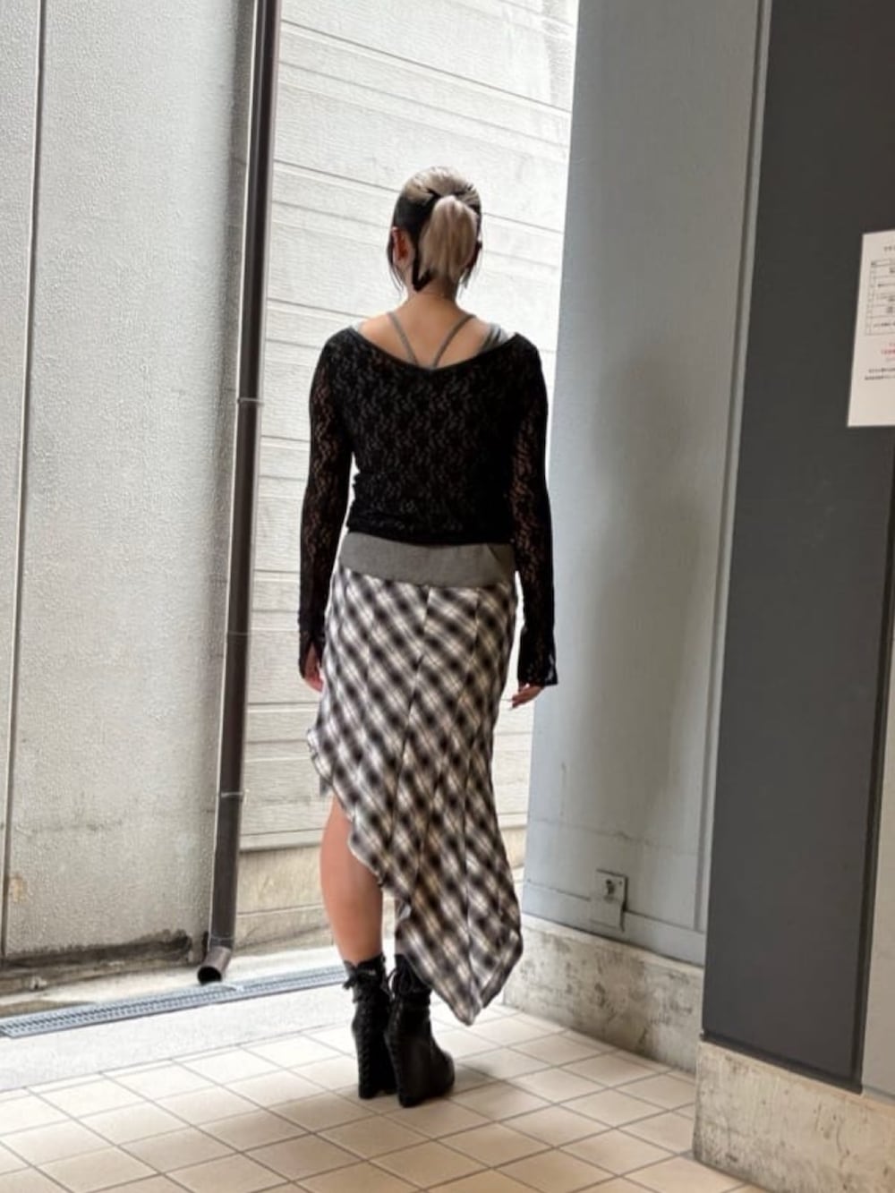 ブラック系のスカート、ホワイト系のTシャツ/カットソー、ブラック系のTシャツ/カットソーを着用したレディースの秋コーディネートの3枚目の写真