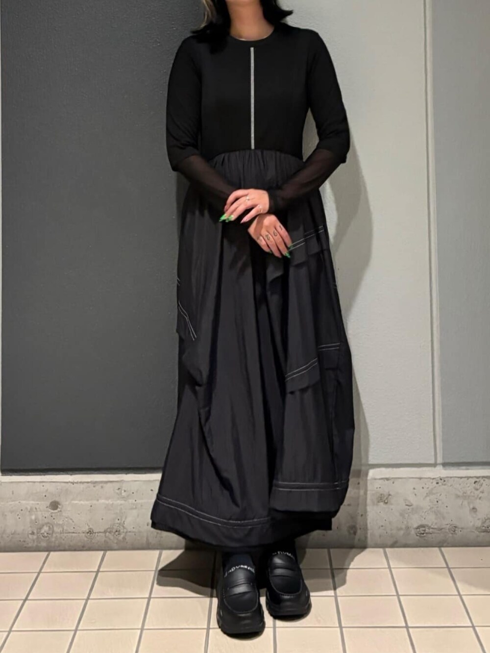 ブラック系のワンピース、ブラック系のローファーを着用したレディースの秋コーディネートの5枚目の写真