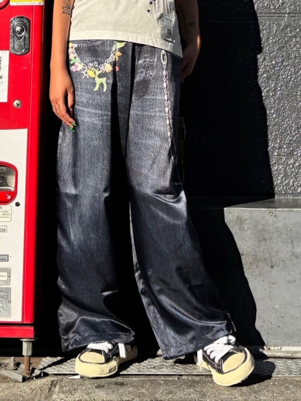 ブラック系のスニーカー、ブルー系のパンツ、ホワイト系のTシャツ/カットソーを着用したレディースの秋コーディネートの4枚目の写真