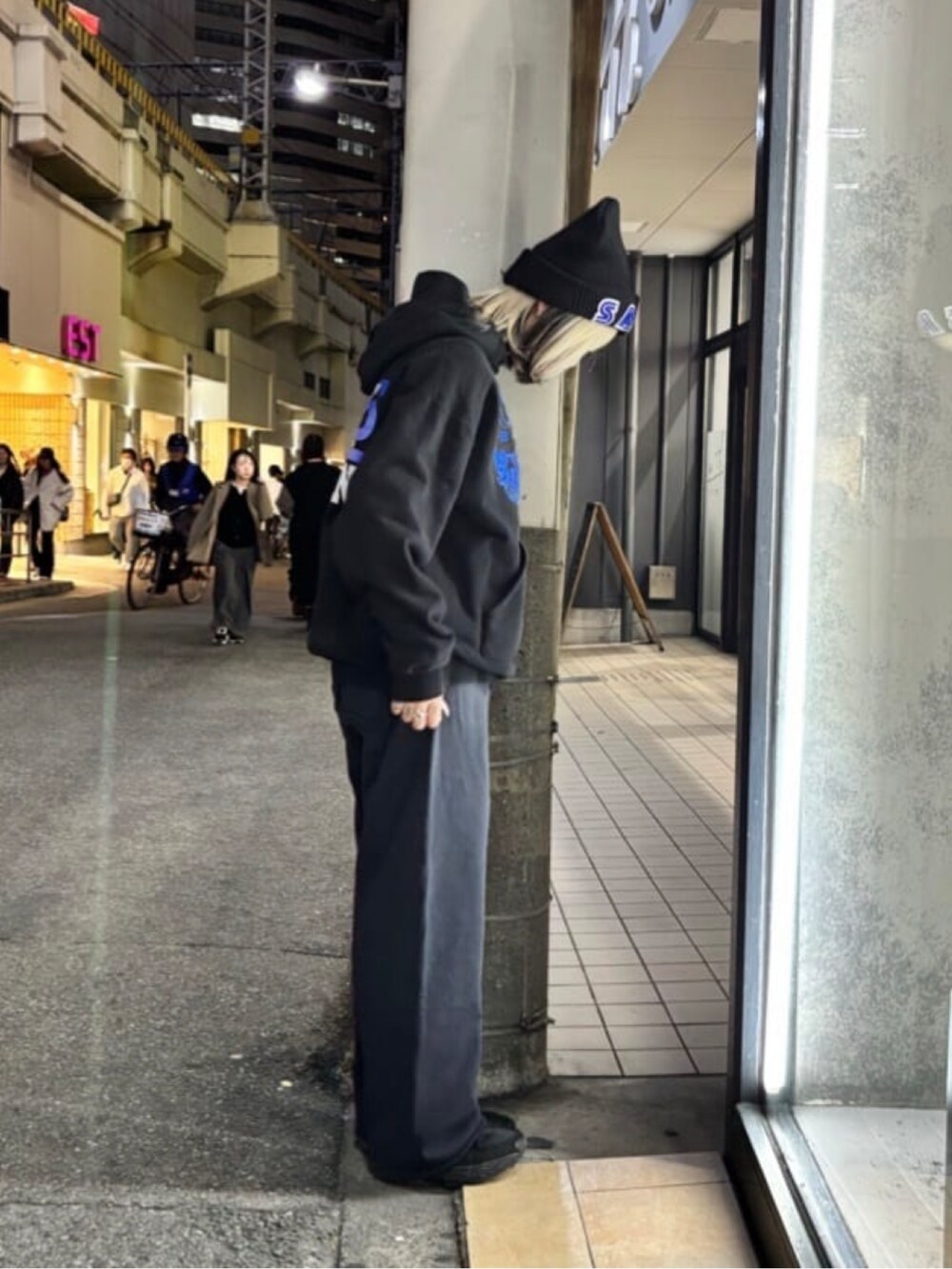 ブラック系のトップス、ブルー系のパンツ、ブラック系の帽子を着用したレディースの冬コーディネートの3枚目の写真