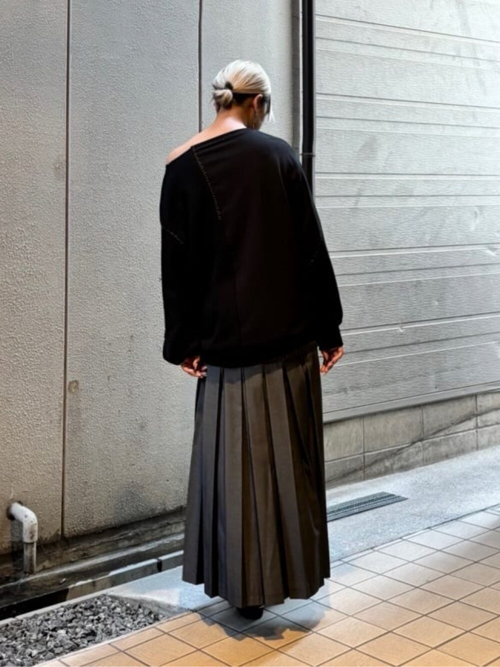 グレー系のスカート、ブラック系のトップスを着用したレディースの秋コーディネートの4枚目の写真