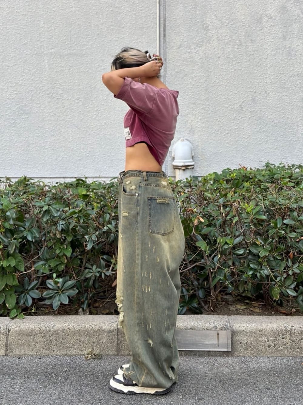 レッド系のTシャツ/カットソー、ブルー系のデニムパンツを着用したレディースの秋コーディネートの2枚目の写真