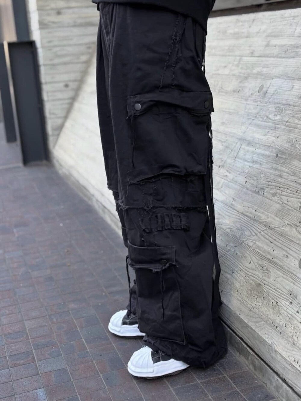 ブラック系のスニーカー、ブラック系のパンツ、ブラック系のパーカーを着用したレディースの秋コーディネートの4枚目の写真