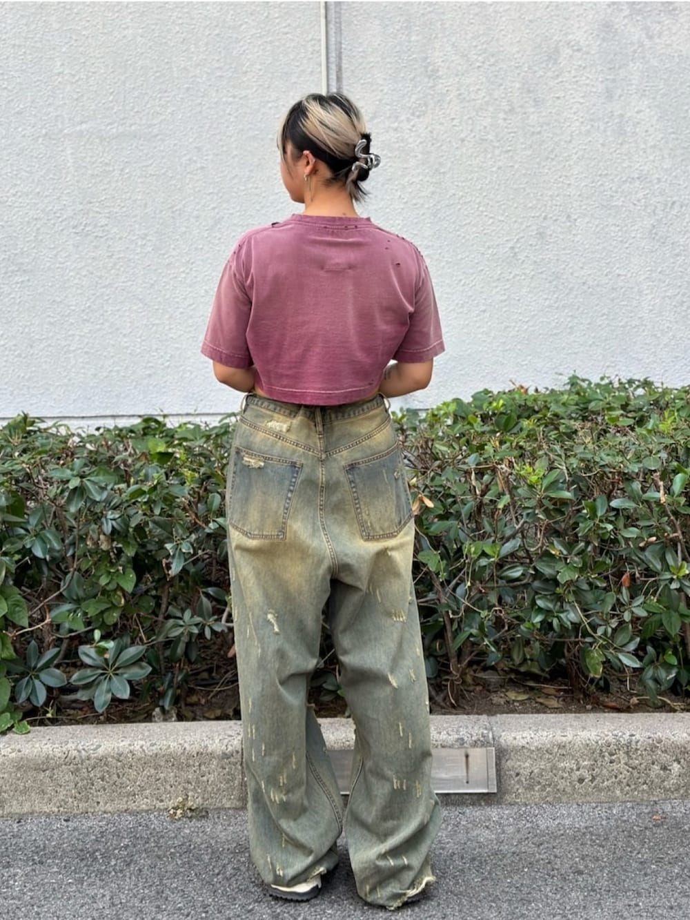 レッド系のTシャツ/カットソー、ブルー系のデニムパンツを着用したレディースの秋コーディネートの3枚目の写真