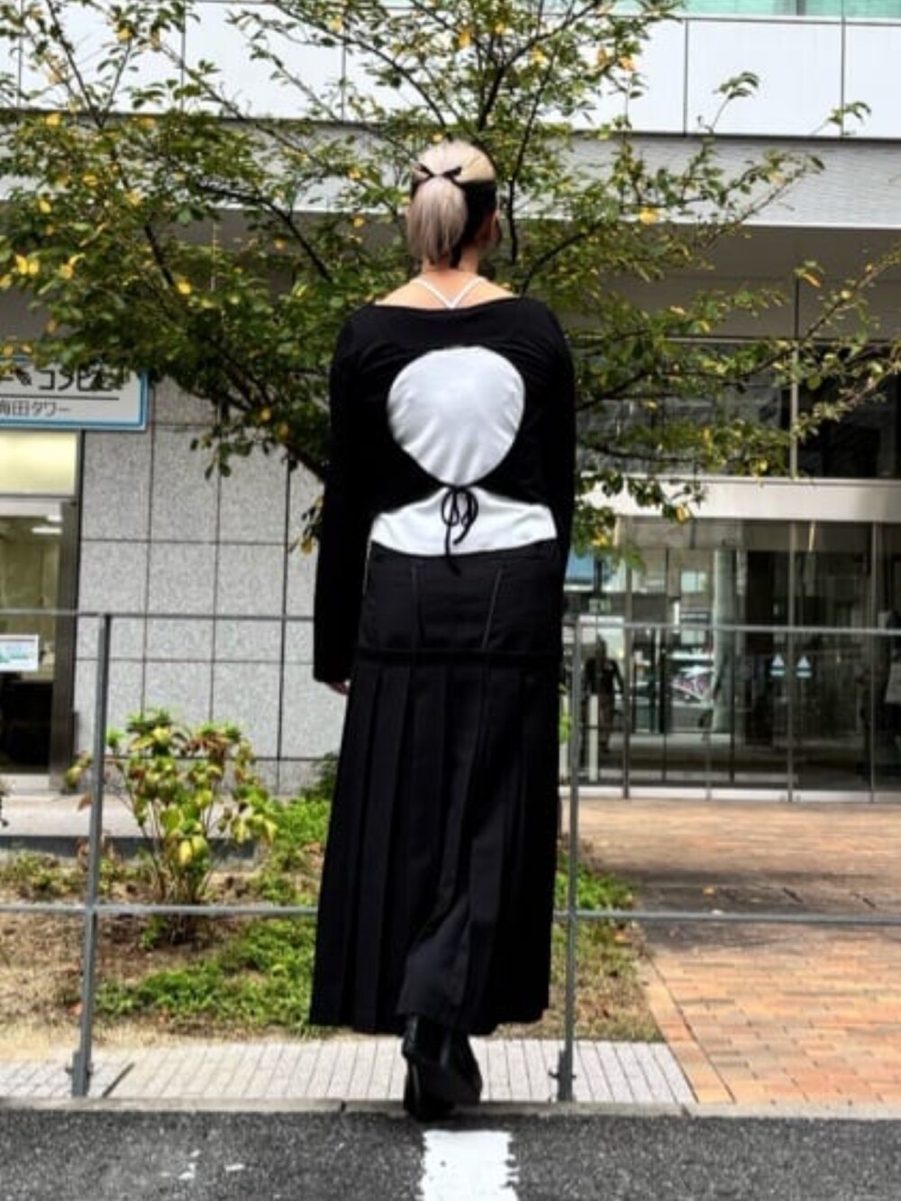 ブラック系のスカート、ホワイト系のTシャツ/カットソーを着用したレディースの秋コーディネートの4枚目の写真