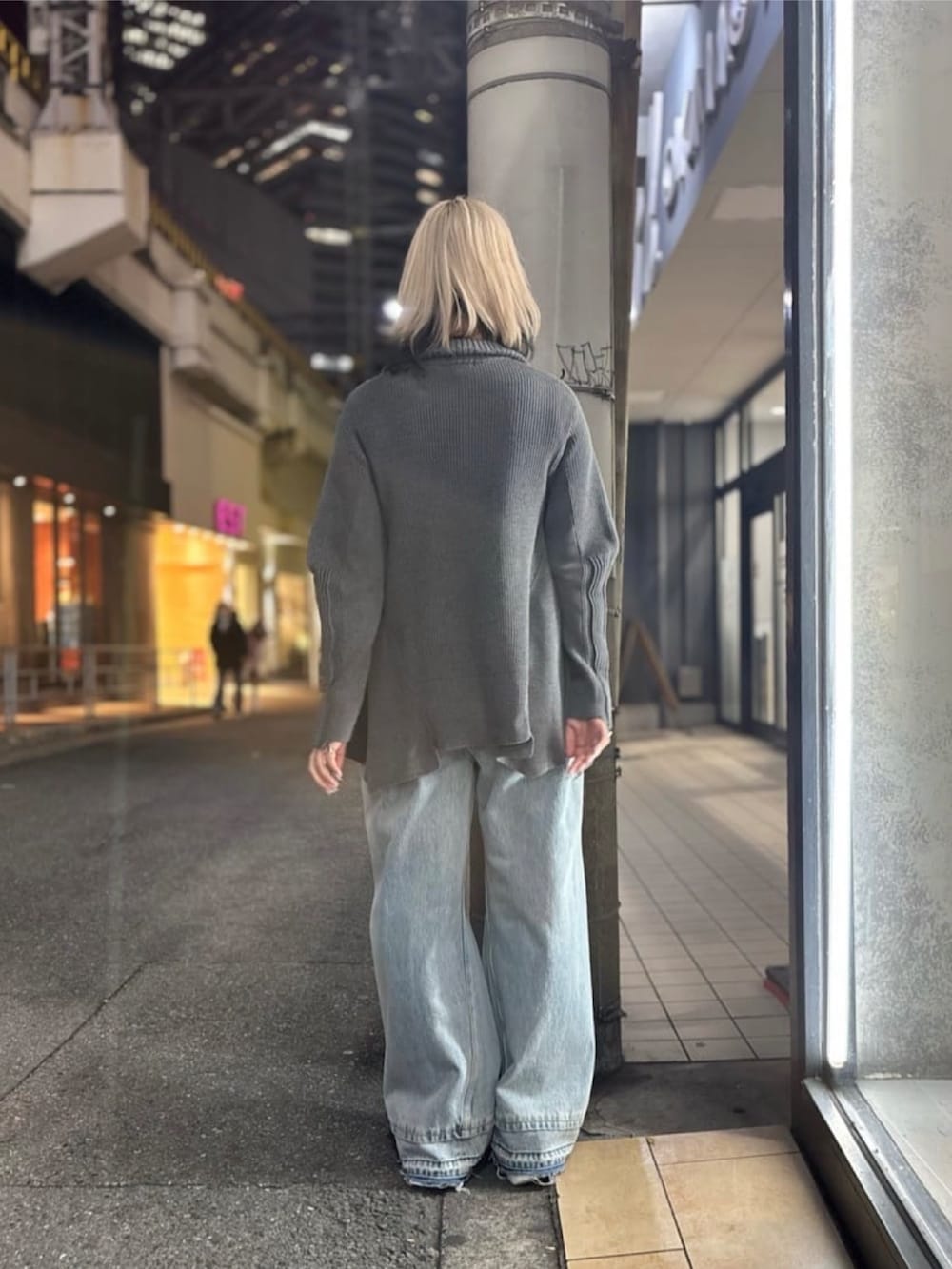 グレー系のニット/セーター、ブルー系のデニムパンツ、ホワイト系のシューズを着用したレディースの冬コーディネートの3枚目の写真