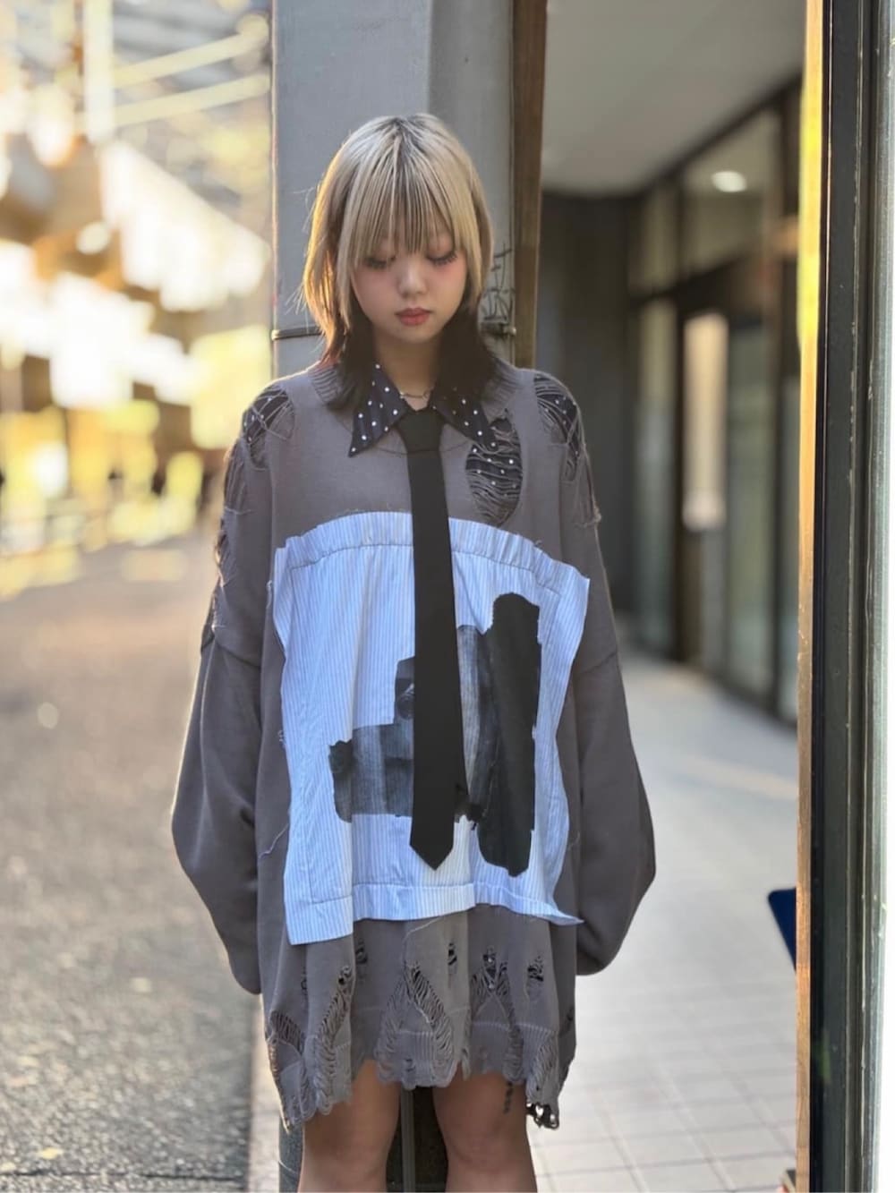 ブラック系のスニーカー、グレー系のニット/セーター、ブラック系のシャツ/ブラウスを着用したレディースの冬コーディネートの4枚目の写真