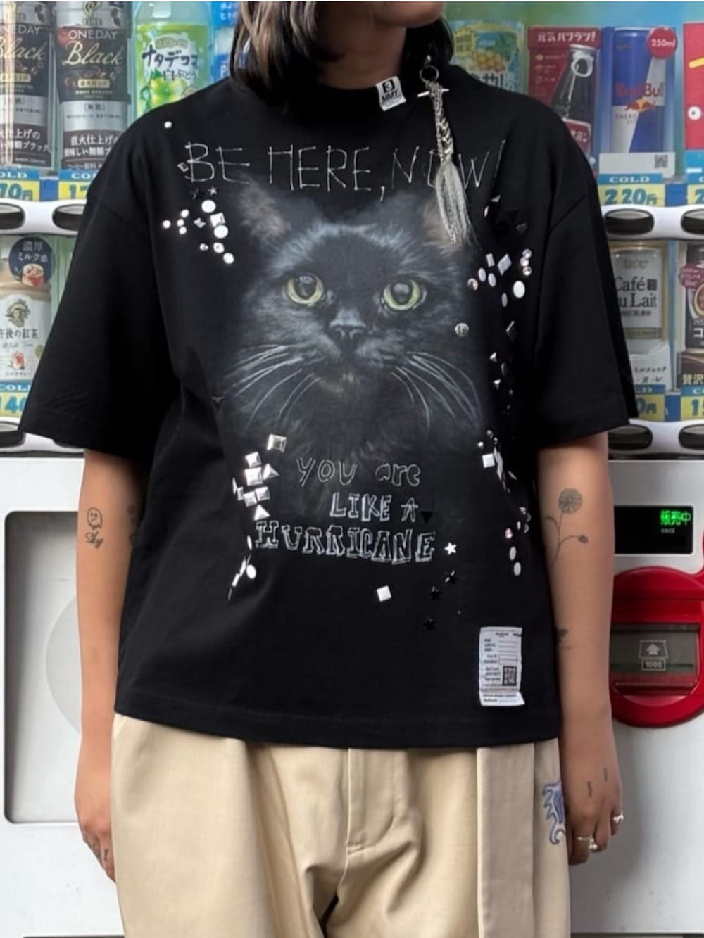 ブラック系のスニーカー、ベージュ系のチノパンツ、ブラック系のTシャツ/カットソーを着用したレディースの秋コーディネートの3枚目の写真