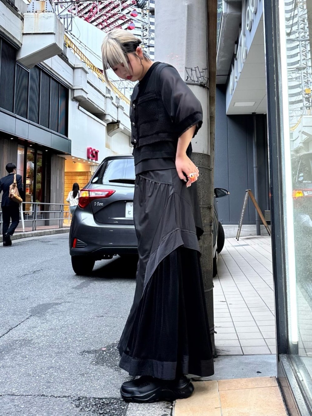 ブラック系のスカート、ブラック系のTシャツ/カットソー、ブラック系のローファーを着用したレディースの夏コーディネートの2枚目の写真