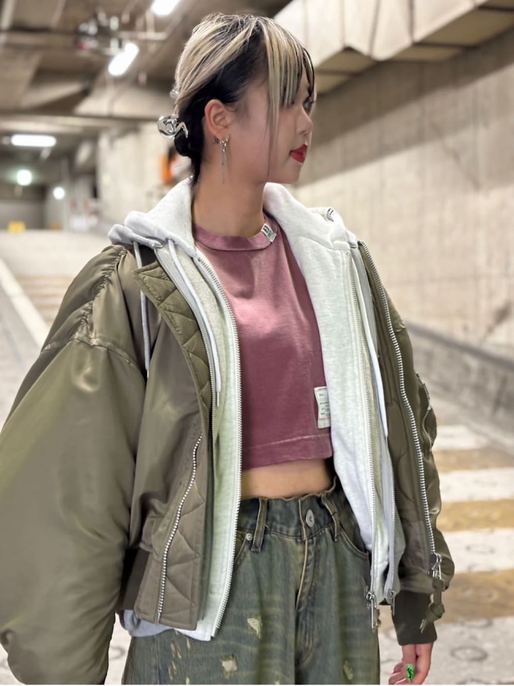 グリーン系のジャケット/アウター、レッド系のTシャツ/カットソー、ブルー系のデニムパンツを着用したレディースの秋コーディネートの5枚目の写真