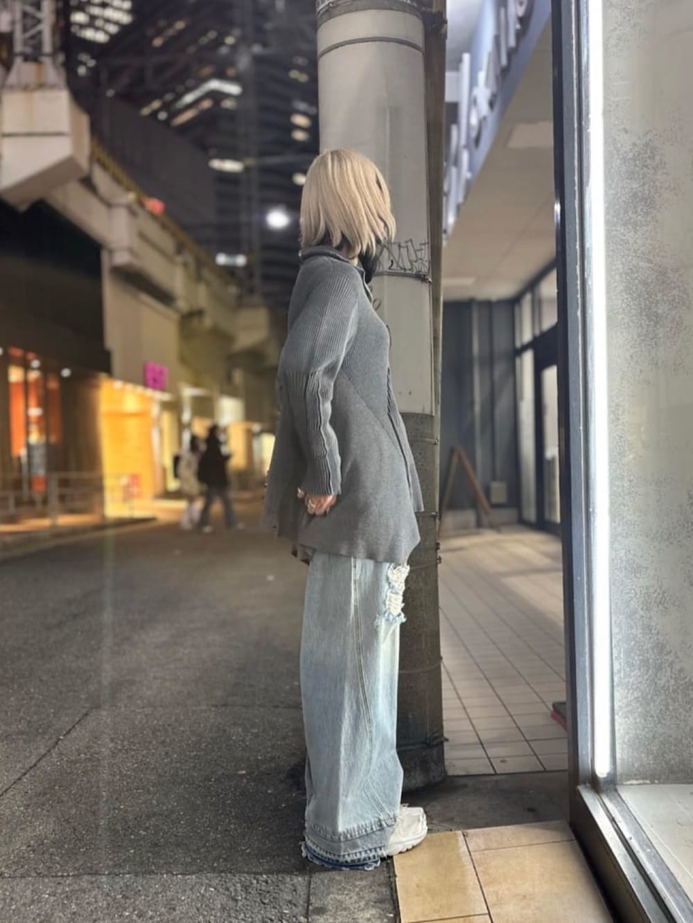 グレー系のニット/セーター、ブルー系のデニムパンツ、ホワイト系のシューズを着用したレディースの冬コーディネートの2枚目の写真