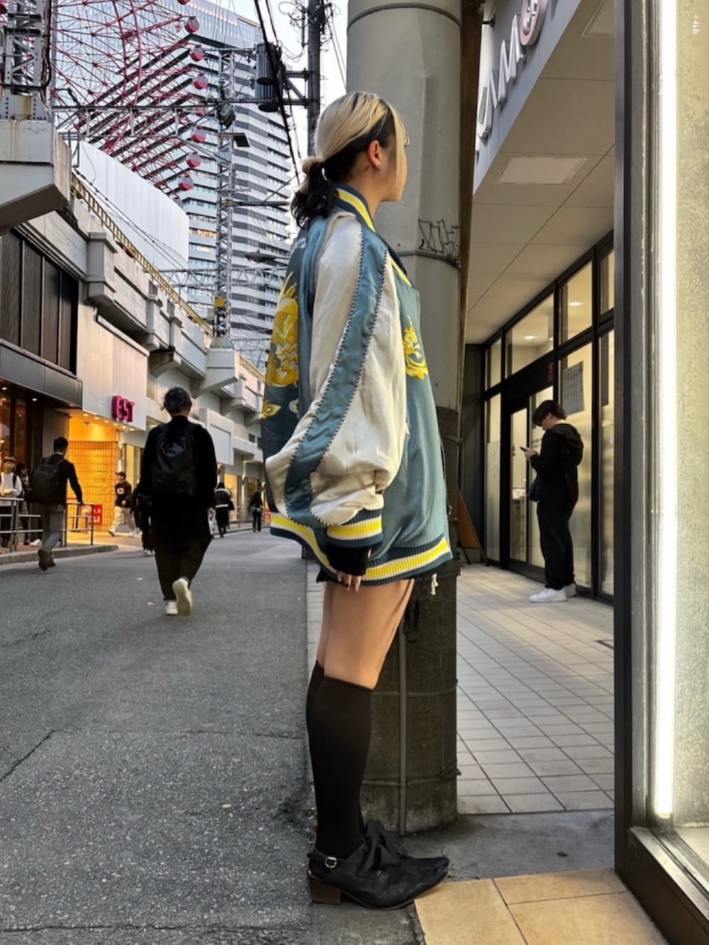 ブルー系のスカジャンを着用したレディースの冬コーディネートの2枚目の写真