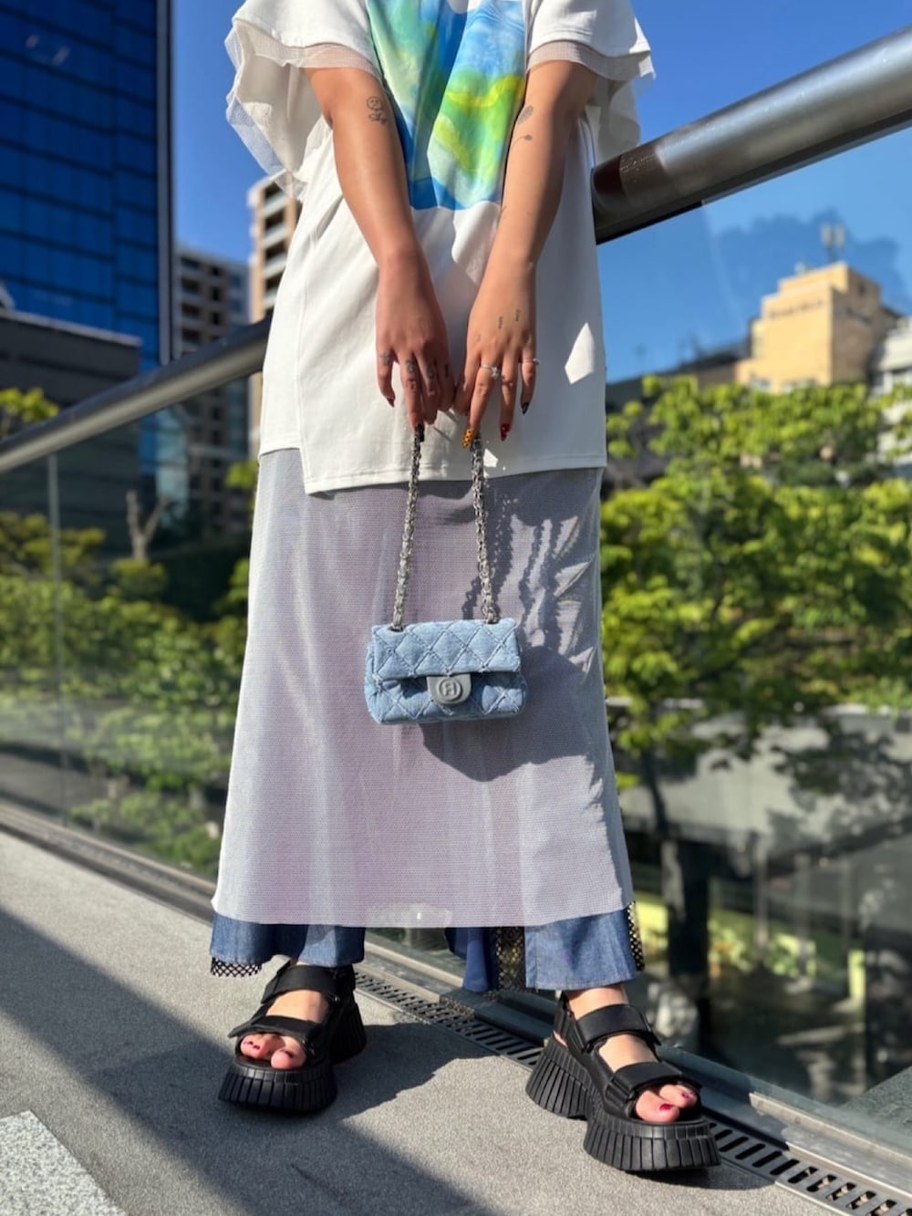 ホワイト系のチュニック、ブルー系のワンピース、ブルー系のバッグを着用したレディースの秋コーディネートの5枚目の写真