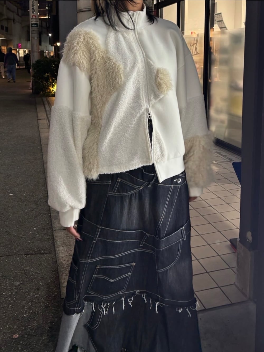 ブラック系のスカート、ホワイト系のブルゾン、ブラック系のスニーカーを着用したレディースの冬コーディネートの5枚目の写真