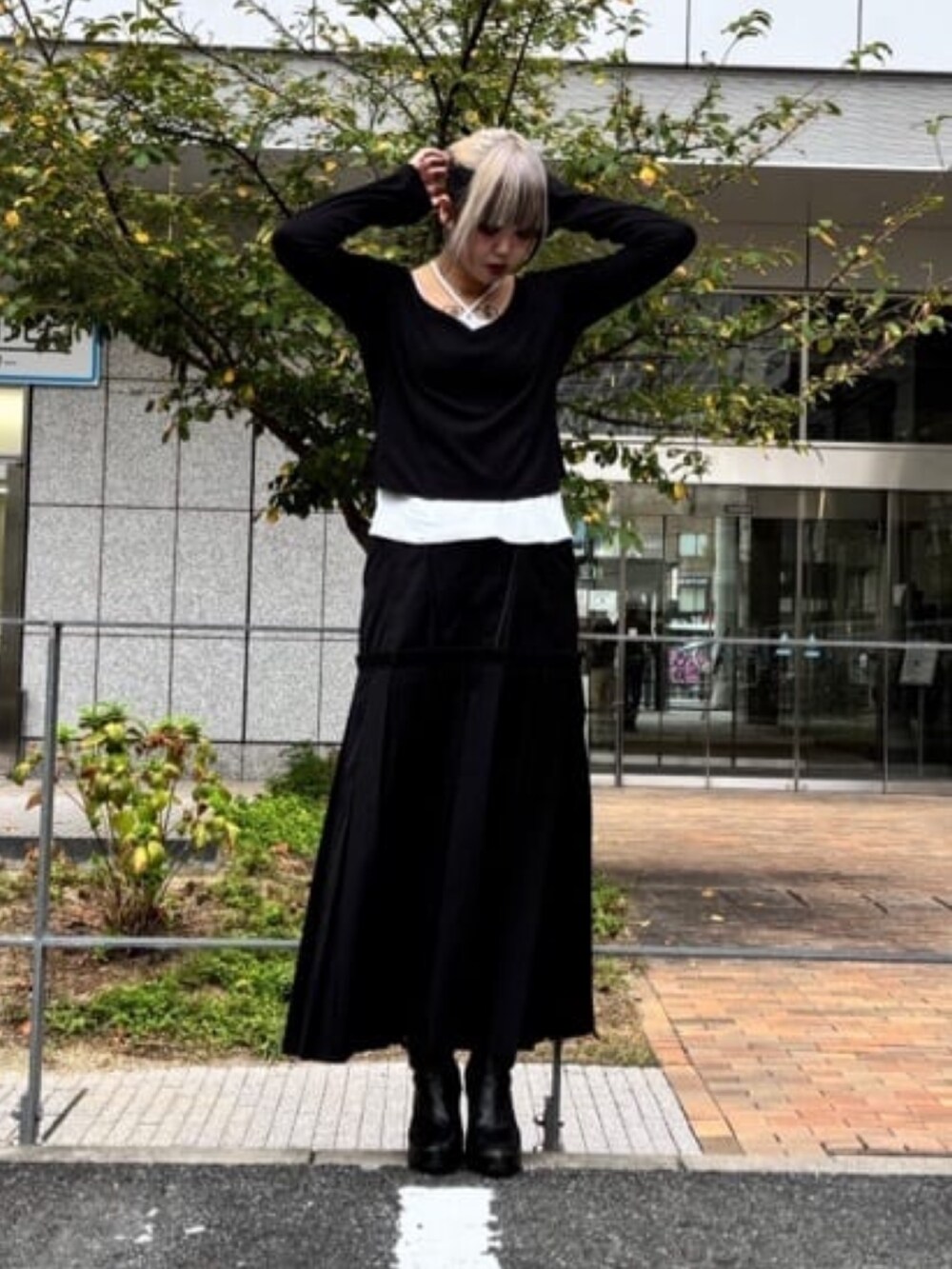 ブラック系のスカート、ホワイト系のTシャツ/カットソーを着用したレディースの秋コーディネートの2枚目の写真