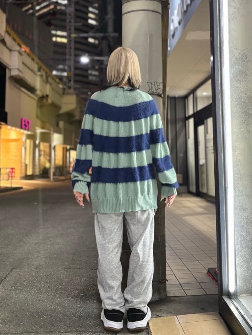 ブルー系のニット/セーター、グレー系のパンツ、ブラック系のスニーカーを着用したレディースの冬コーディネートの3枚目の写真