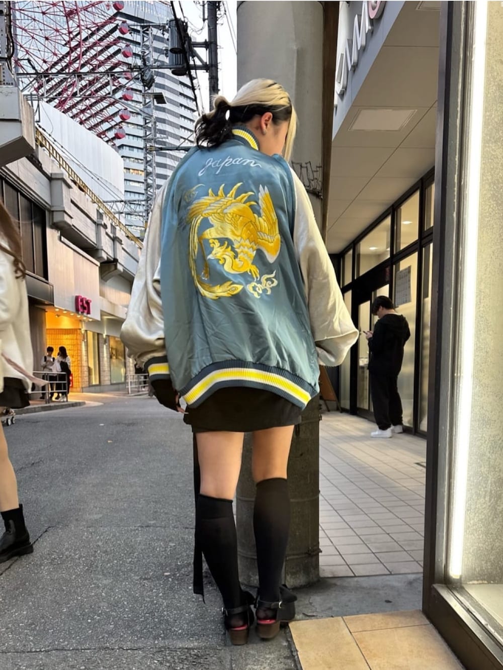 ブルー系のスカジャンを着用したレディースの冬コーディネートの3枚目の写真