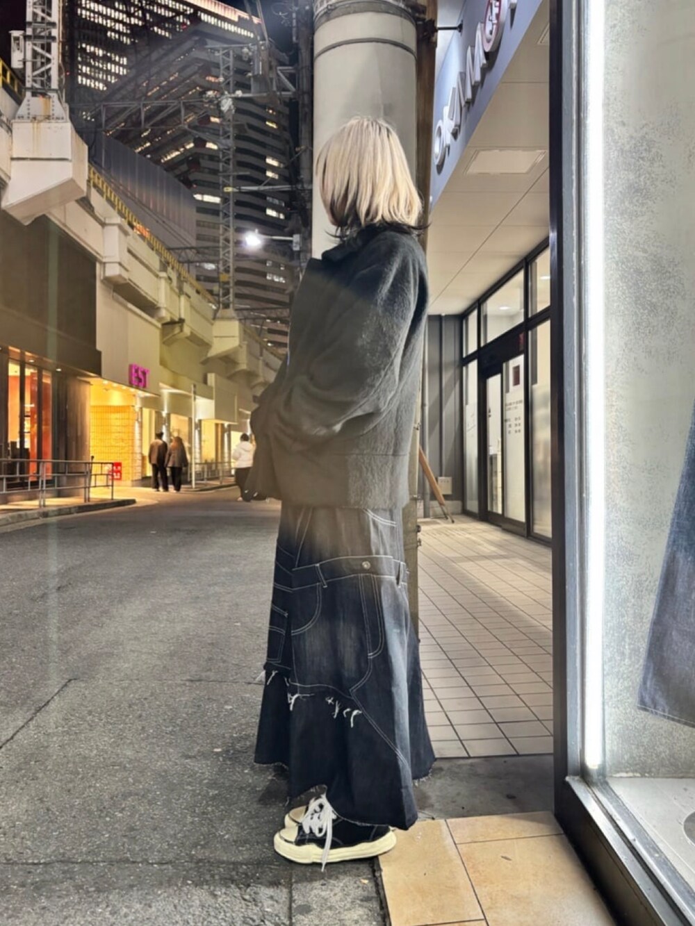 ブラック系のその他アウター、ブラック系のスカート、ブルー系のニット/セーターを着用したレディースの冬コーディネートの2枚目の写真