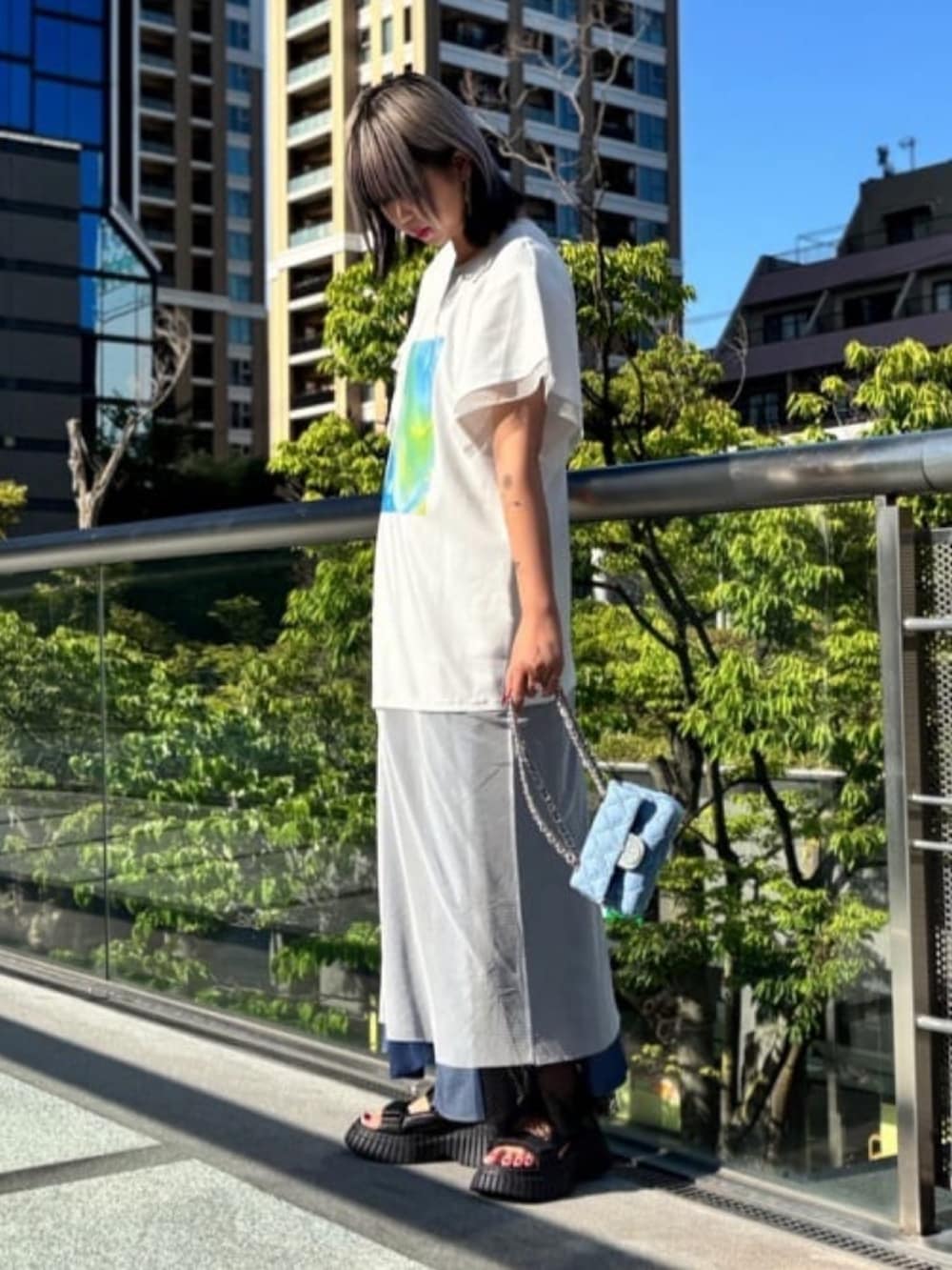 ホワイト系のチュニック、ブルー系のワンピース、ブルー系のバッグを着用したレディースの秋コーディネートの2枚目の写真