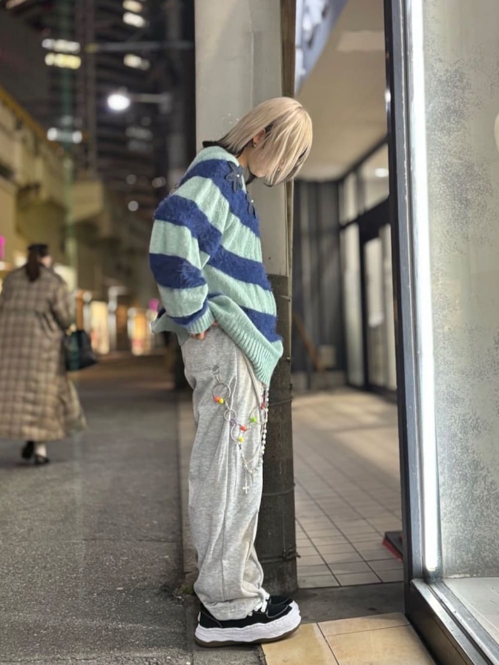 ブルー系のニット/セーター、グレー系のパンツ、ブラック系のスニーカーを着用したレディースの冬コーディネートの4枚目の写真