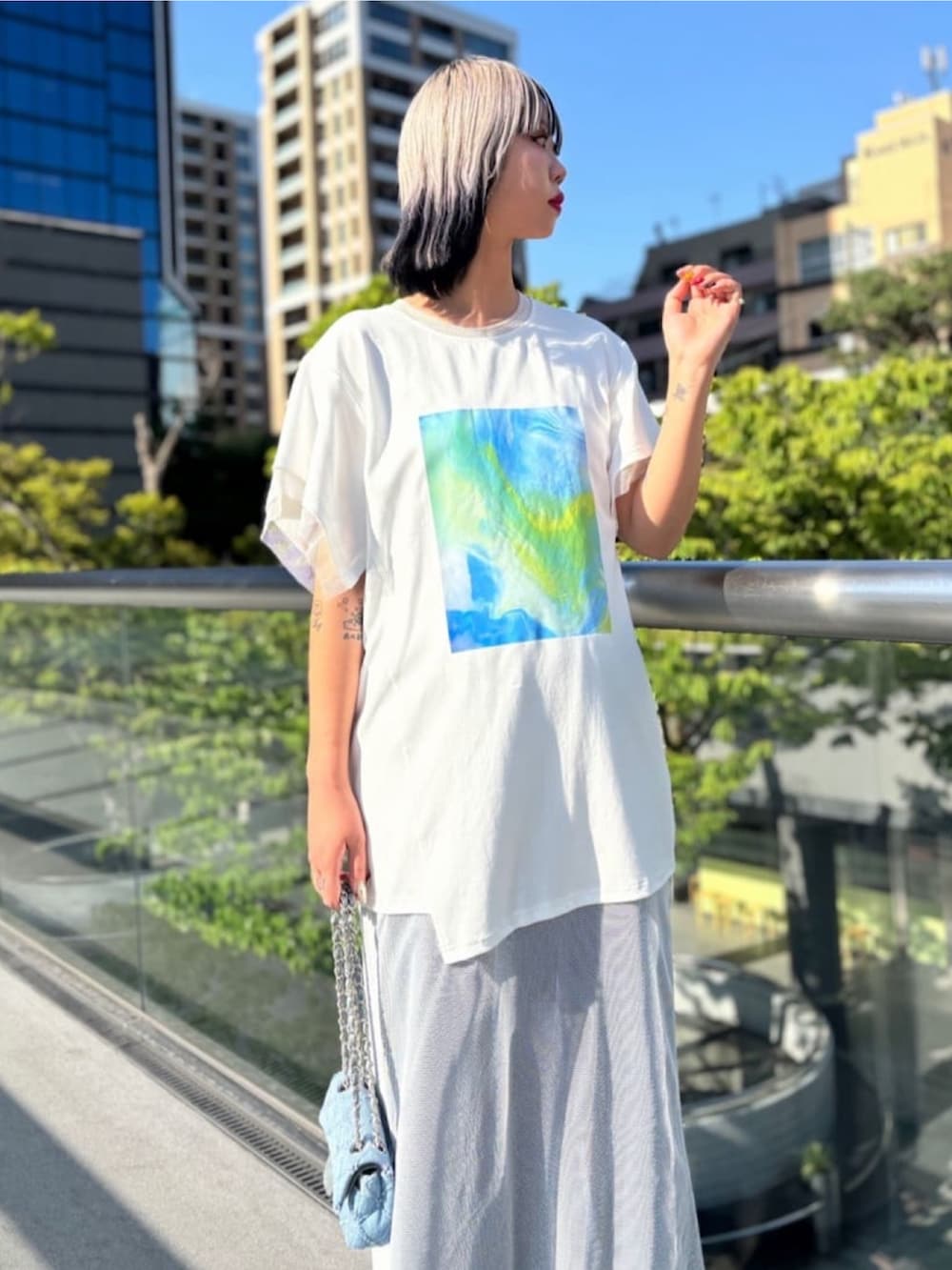 ホワイト系のチュニック、ブルー系のワンピース、ブルー系のバッグを着用したレディースの秋コーディネートの4枚目の写真