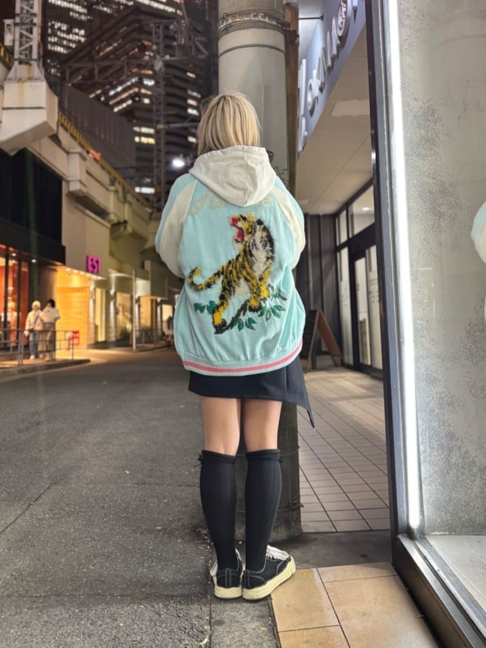 ホワイト系のパーカー、ブルー系のジャケット/アウター、ブラック系のスニーカーを着用したレディースの冬コーディネートの3枚目の写真