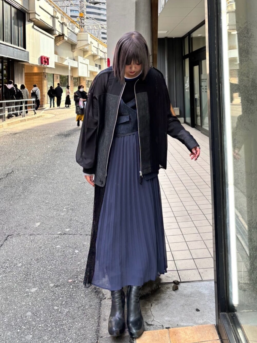 ブルー系のワンピース、ブラック系のTシャツ/カットソー、ブラック系のブルゾンを着用したレディースの春コーディネートの3枚目の写真